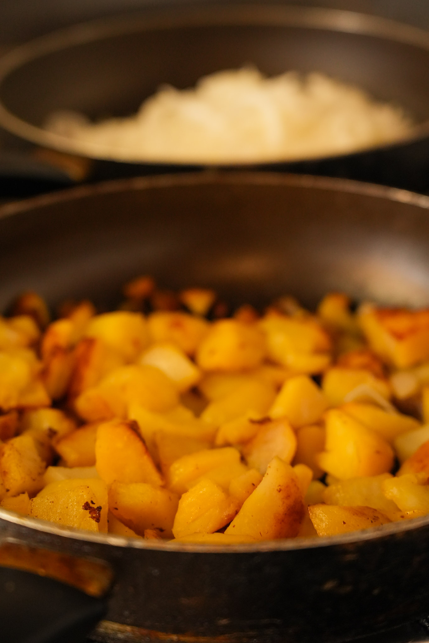 Bratkartoffeln mit goldbraunen Zwiebeln in der Pfanne